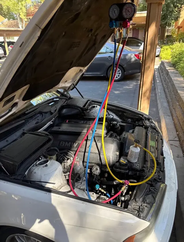 A/C recharge on a BMW in an apartment carport