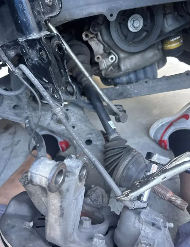 CV axle and front suspension repair in a driveway