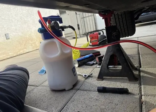 Fluid service on jack stands in a customer's driveway